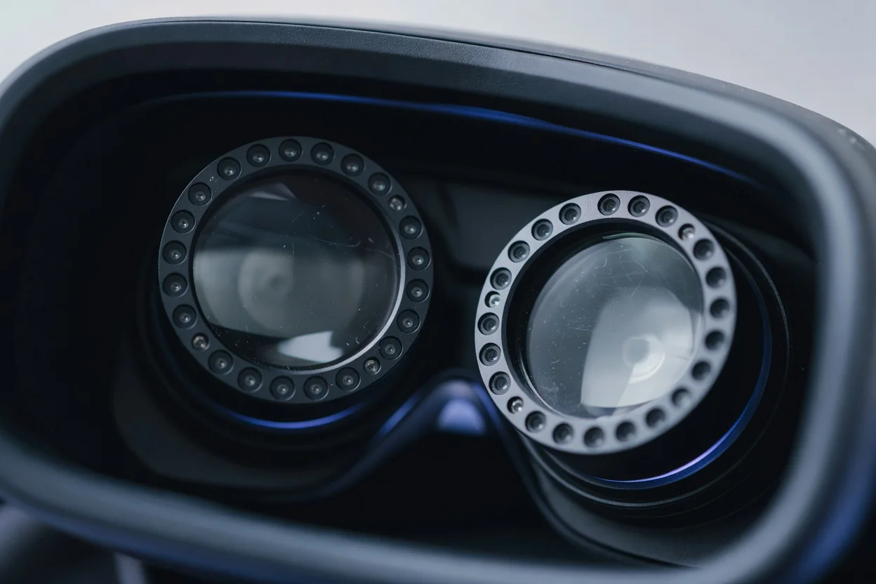 Extreme close-up of VR headset interior lenses surrounded by small infrared sensor rings on a dark background